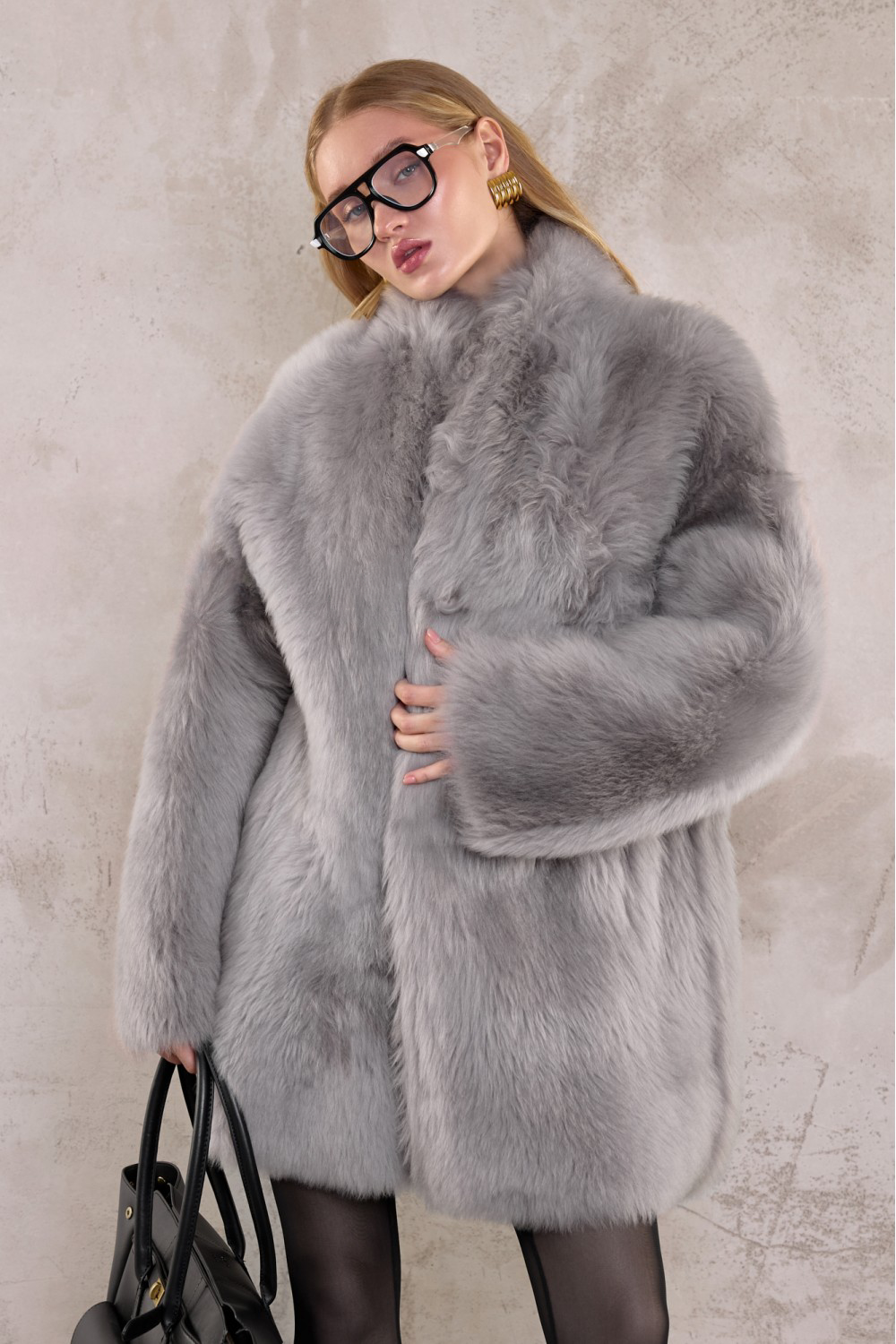 Woman wearing a light grey Tuscan shearling coat, showcasing premium winter elegance.